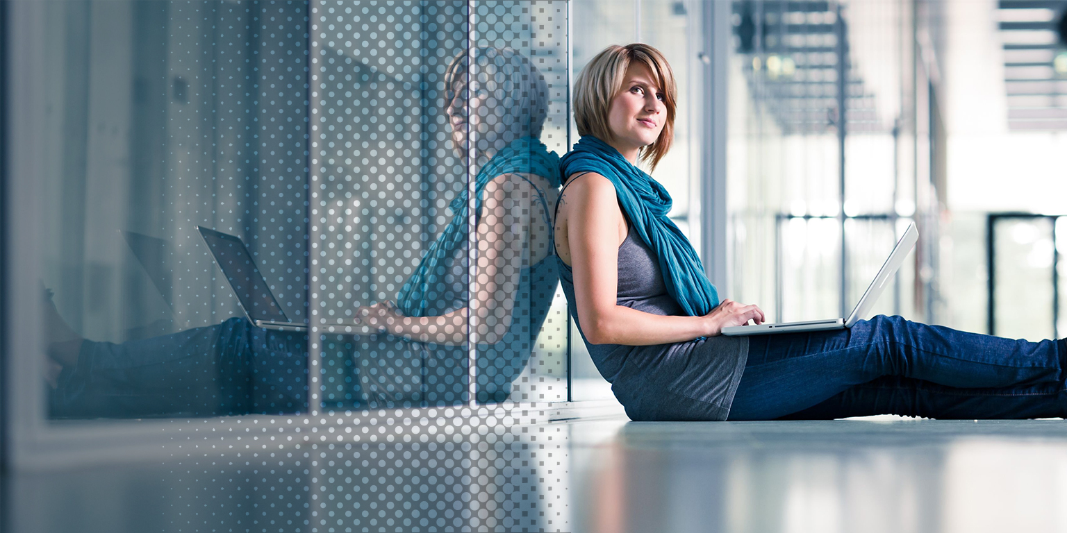 A lady using laptop happy in a office