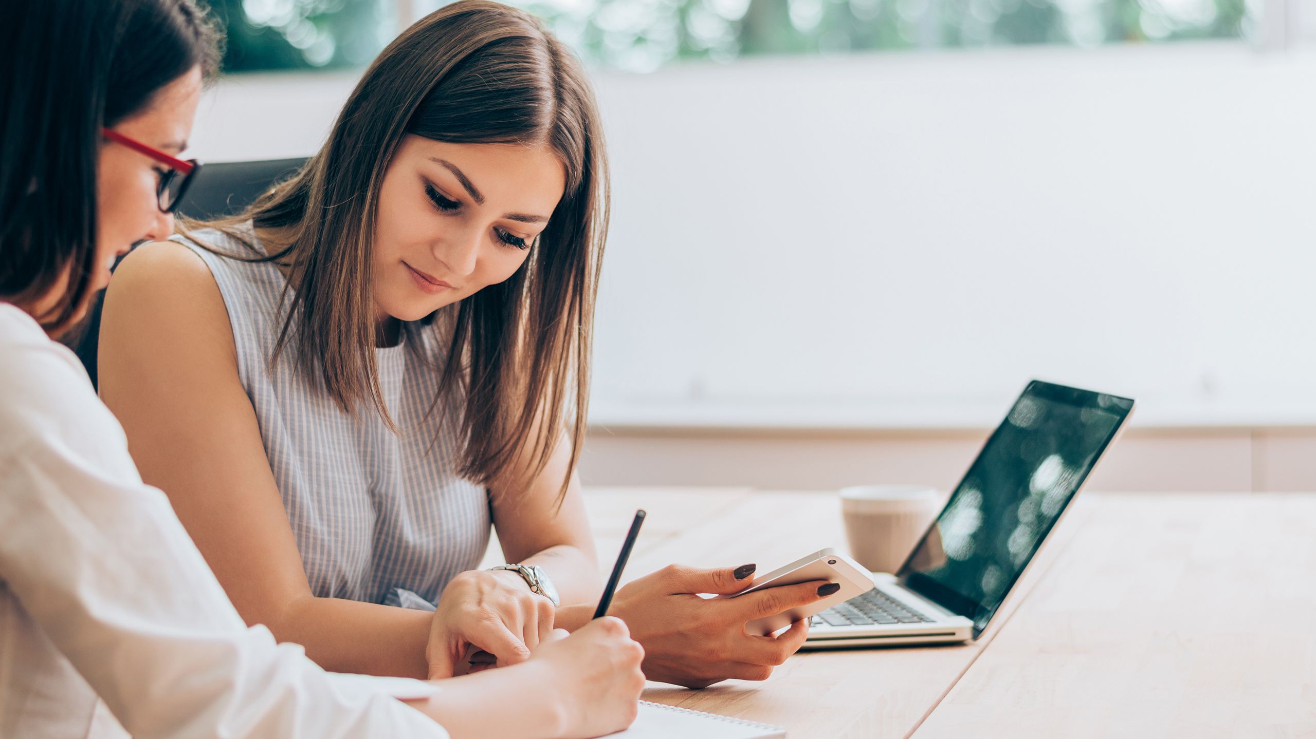 Happy woman employees working at office with a laptop